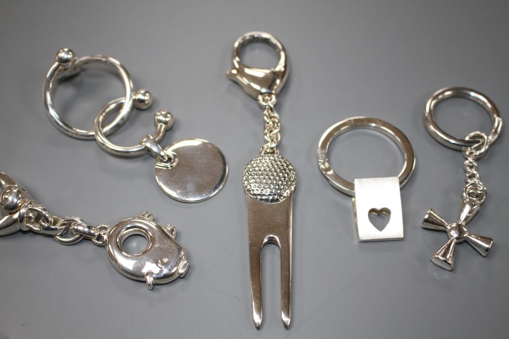 Seven assorted modern silver keyrings including novelty pig and horses head,